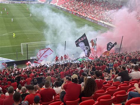 DVSC szurkolók piros-fehér látványelemekkel egy stadionban