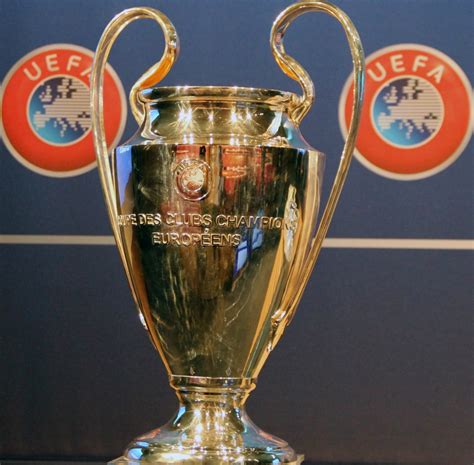 A Manchester City csapatának logója és a Bajnokok Ligája trófea