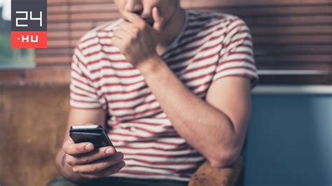 Mobiltelefonon focit néző ember