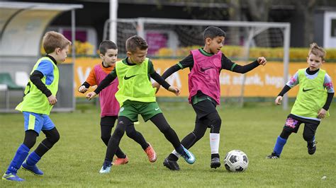 gyerekek fociznak egy füves pályán