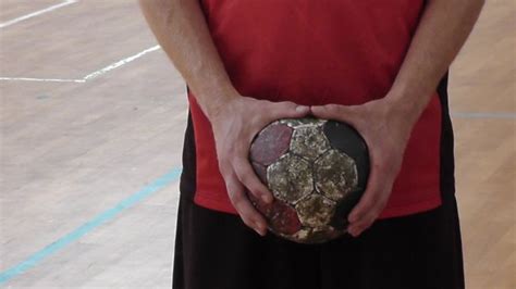 Kézilabdás játékos két kézzel fogja a labdát