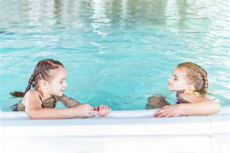 Gyermekek boldogan pancsolnak a medencében