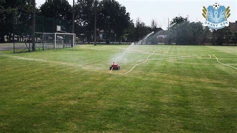 Önjáró öntözőkocsi működés közben egy futballpályán
