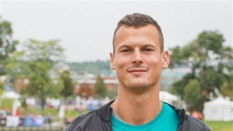 Baji Balázs futás közben, háttérben stadionnal