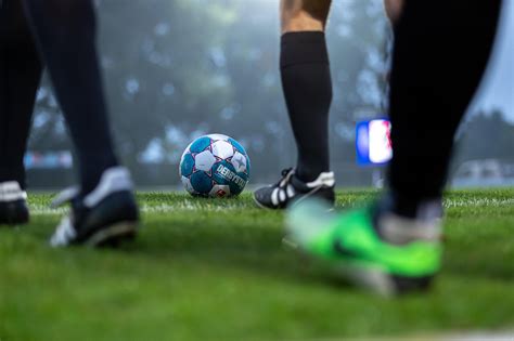 Kép: Futball stadion nézőkkel, fókuszban a pálya szélén álló edző