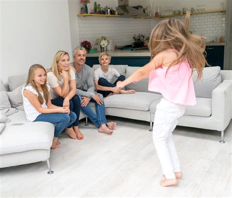 Mosolygó család játszik társasjátékkal a padlón