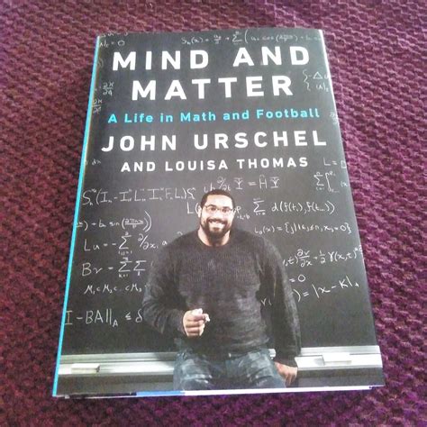 John Urschel képe, amint egyszerre tart focilabdát és egy matematikai könyvet