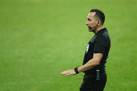 Labdarúgó játékvezetők egy mérkőzésen, amint figyelmesen követik a játékot