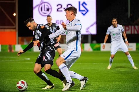 Amerikaifutball-mérkőzés a pályán, sisakos játékosokkal