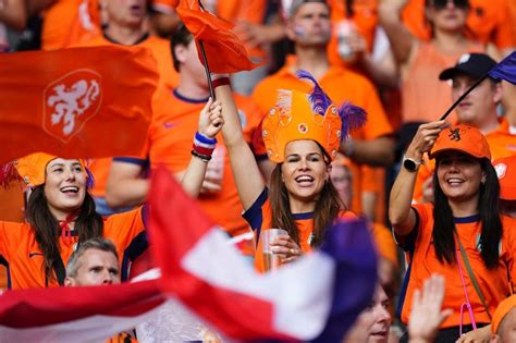 Szurkolók narancssárga mezben, holland zászlók a stadionban