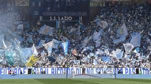 Lazio szurkolók a Curva Nord szektorban, transzparensekkel és zászlókkal az Avanti Ragazzi di Buda dal éneklése közben