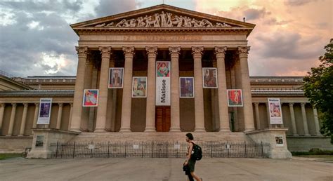 Múzeumok Éjszakája logója egy budapesti múzeum előtt éjszakai fényekben