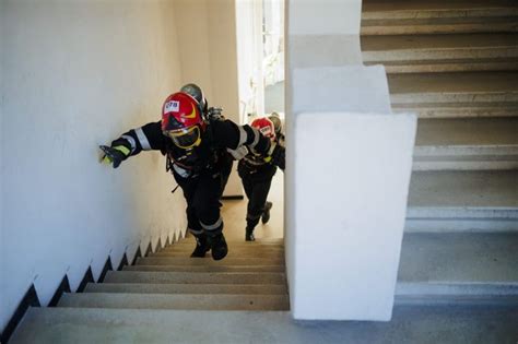 Tűzoltók teljes felszerelésben lépcsőznek verseny közben
