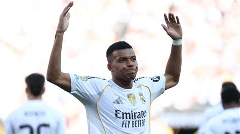 Kylian Mbappé mosolyogva a Real Madrid mezében