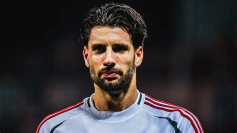 Futballszurkolók néznek meccset egy képernyőn egy sportbárban