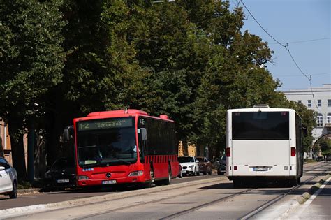 Személygépkocsi a forgalomban, háttérben irodaházak, utalva a munkába járásra.