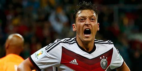 Mesut Özil, amint aláírja szerződését az Arsenallal Arséne Wenger mellett