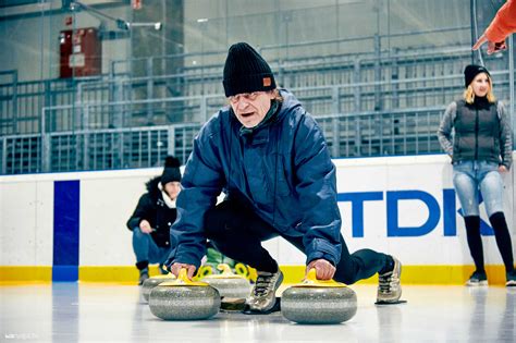 Játékosok söprik a jeget a curling kő előtt